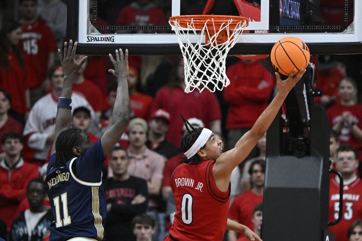 Feb 21, 2026; Louisville, Kentucky, USA;  Louisville Cardinals guard Mikel Brown Jr. (0) shoots against Georgia Tech Yellow Jackets forward Baye Ndongo (11) during the first half at KFC Yum! Center. Mandatory Credit: Jamie Rhodes-Imagn Images