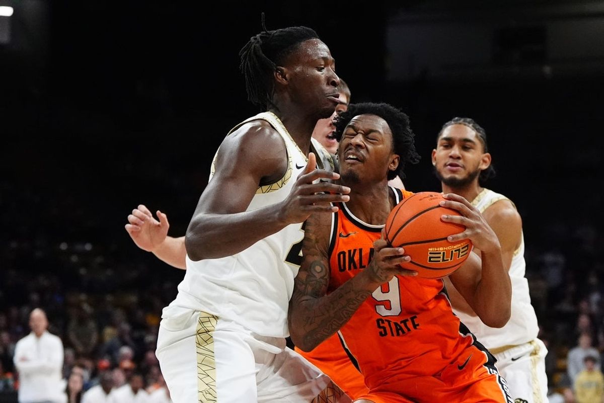Feb 21, 2026; Boulder, Colorado, USA; Oklahoma State Cowboys guard Anthony Roy (9) collides into Colorado Buffaloes center Fawaz Ifaola (25) in the first half at the CU Events Center. Mandatory Credit: Ron Chenoy-Imagn Images