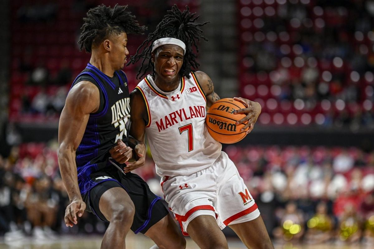 Feb 21, 2026; College Park, Maryland, USA;  Maryland Terrapins guard Andre Mills (7) collides with Washington Huskies guard Courtland Muldrew (30) in the paint during the second  half at Xfinity Center. Mandatory Credit: Tommy Gilligan-Imagn Images