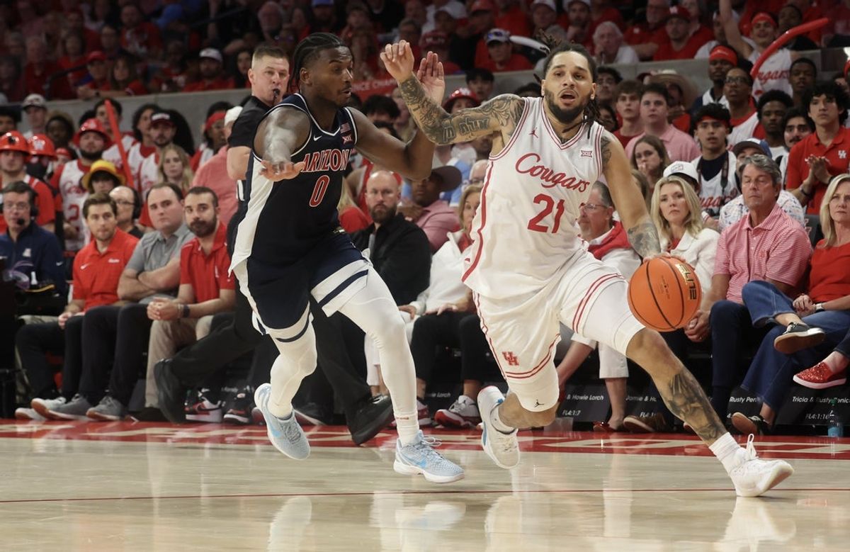 Feb 21, 2026; Houston, Texas, USA; Houston Cougars guard Emanuel Sharp (21) dribbles past Arizona Wildcats guard Jaden Bradley (0)  in the second half at Fertitta Center. Mandatory Credit: Thomas Shea-Imagn Images