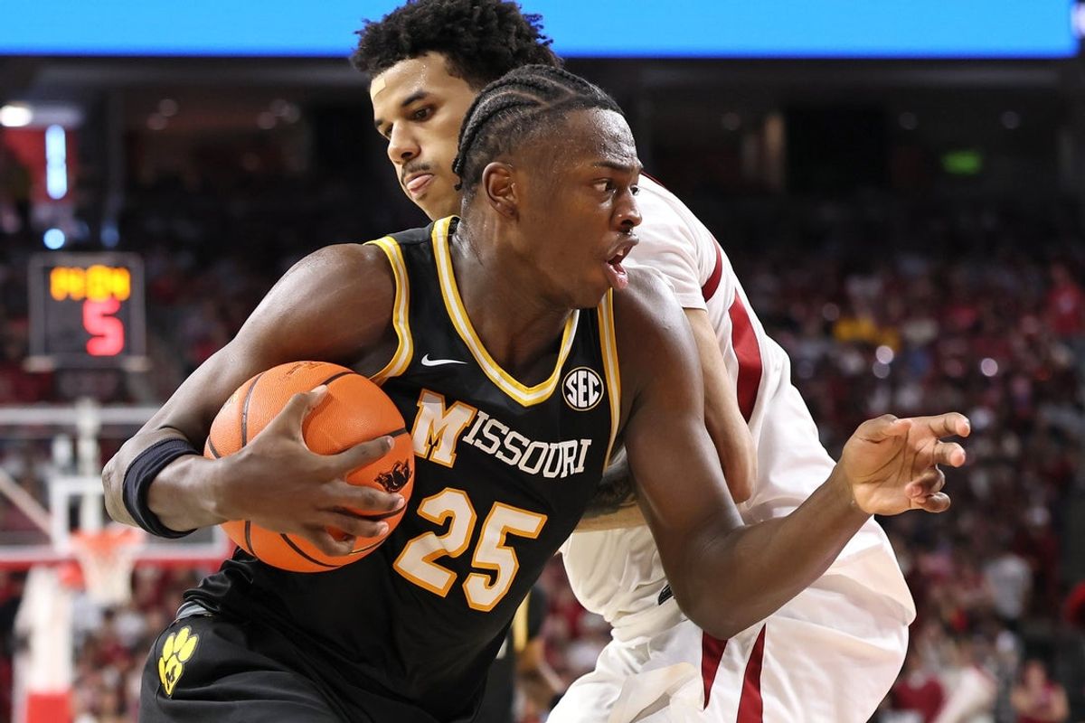 Feb 21, 2026; Fayetteville, Arkansas, USA; Missouri Tigers guard Mark Mitchell (25) drives against Arkansas Razorbacks forward Malique Ewin (12) during the second half at Bud Walton Arena. Arkansas won 94-86. Mandatory Credit: Nelson Chenault-Imagn Images