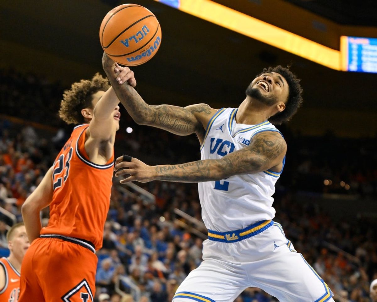Feb 21, 2026; Los Angeles, California, USA; UCLA guard Donovan Dent (2) is fouled by Illinois guard Keaton Wagler (23) as he drives to the basket during the first half at Pauley Pavilion presented by Wescom Financial. Mandatory Credit: Robert Hanashiro-Imagn Images