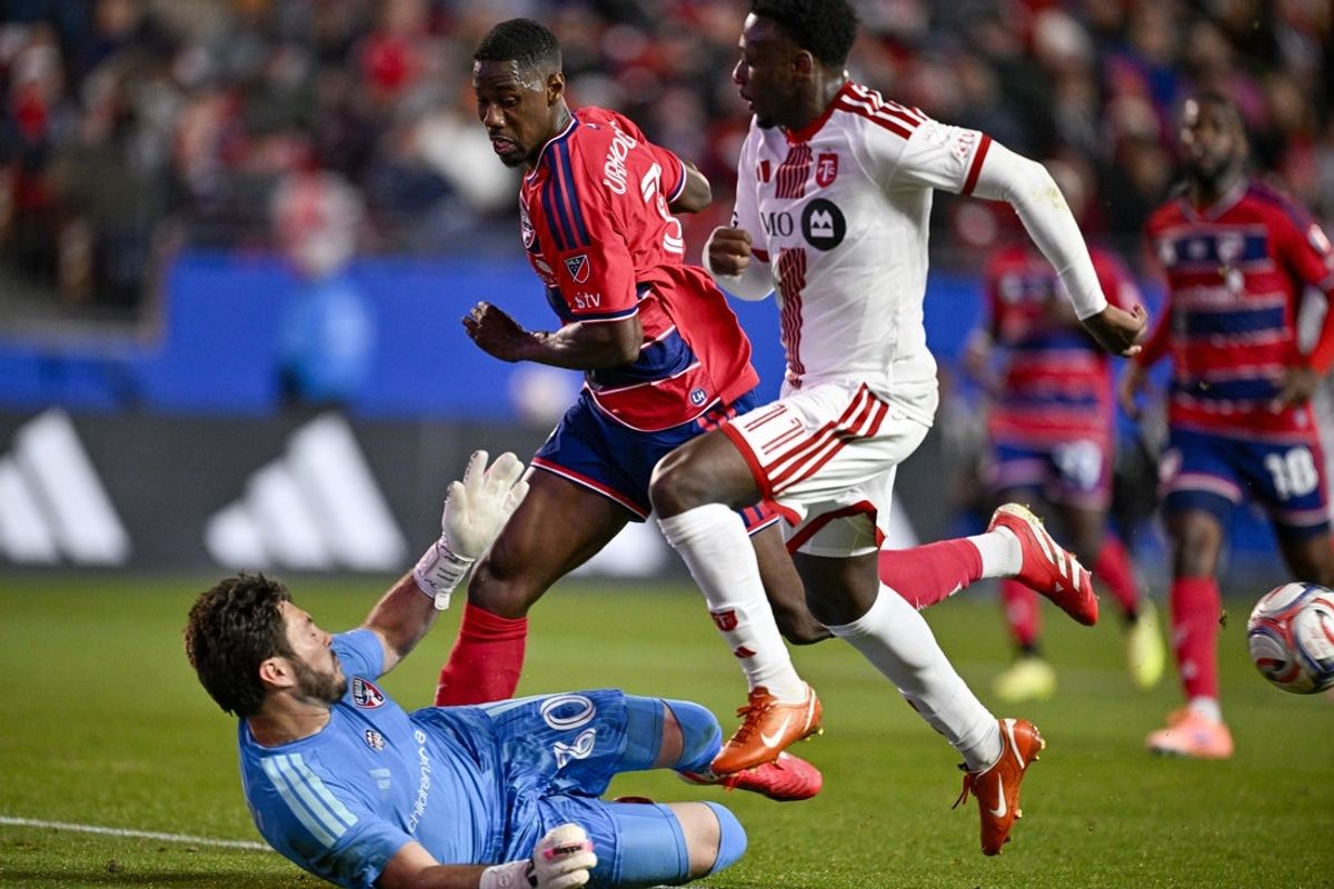 Feb 21, 2026; Frisco, Texas, USA; FC Dallas goalkeeper Michael Collodi (30) knocks the ball away from Toronto FC forward Derrick Etienne Jr. (11) during the first half at Toyota Stadium. Mandatory Credit: Jerome Miron-Imagn Images