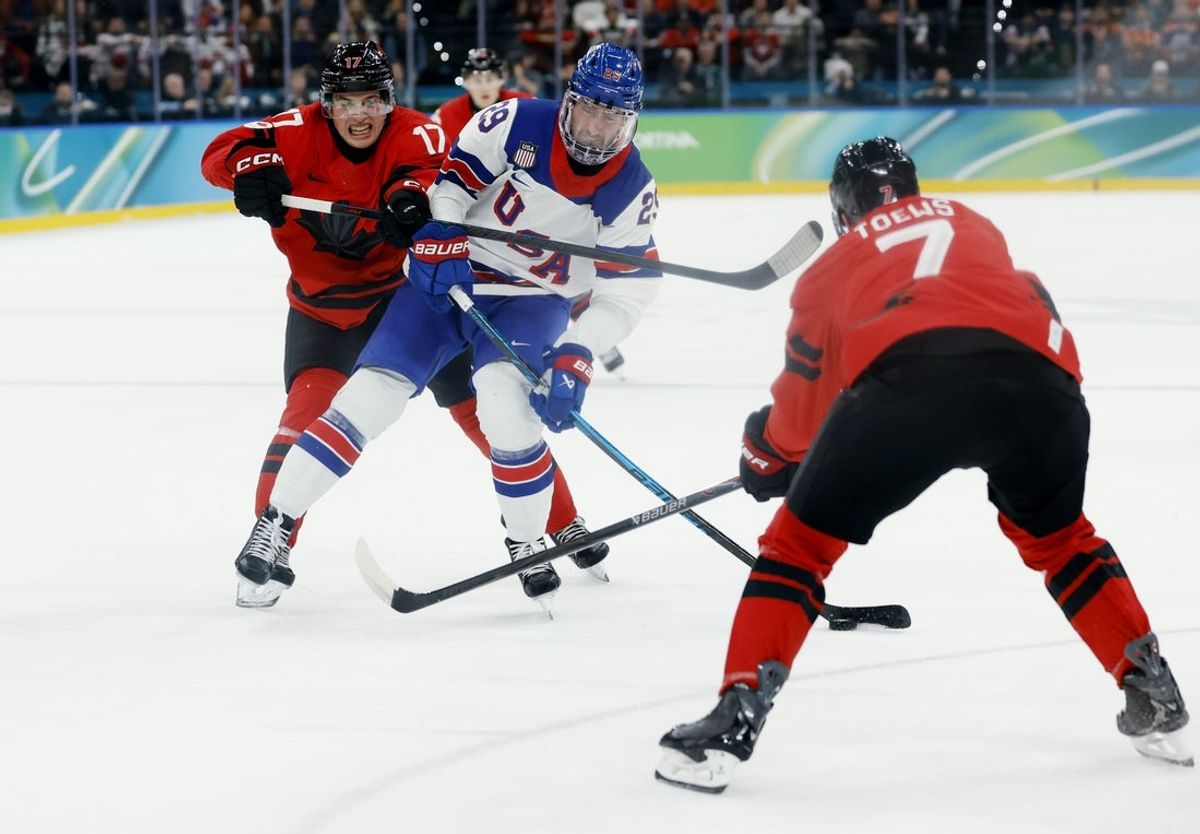 Feb 22, 2026; Milan, Italy; Brock Nelson (29) of the United States is defended by Macklin Celebrini (17) of Canada and Devon Toews (7) of Canada in the men's ice hockey gold medal game during the Milano Cortina 2026 Olympic Winter Games at Milano Santagiulia Ice Hockey Arena. Mandatory Credit: Geoff Burke-Imagn Images