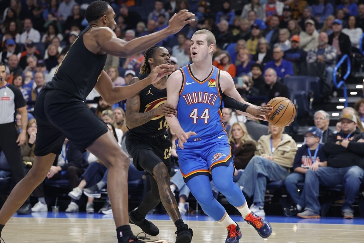 Feb 22, 2026; Oklahoma City, Oklahoma, USA; Oklahoma City Thunder guard Nikola Topic (44) drives past Cleveland Cavaliers guard Keon Ellis (14) during the first half at Paycom Center. Mandatory Credit: Alonzo Adams-Imagn Images