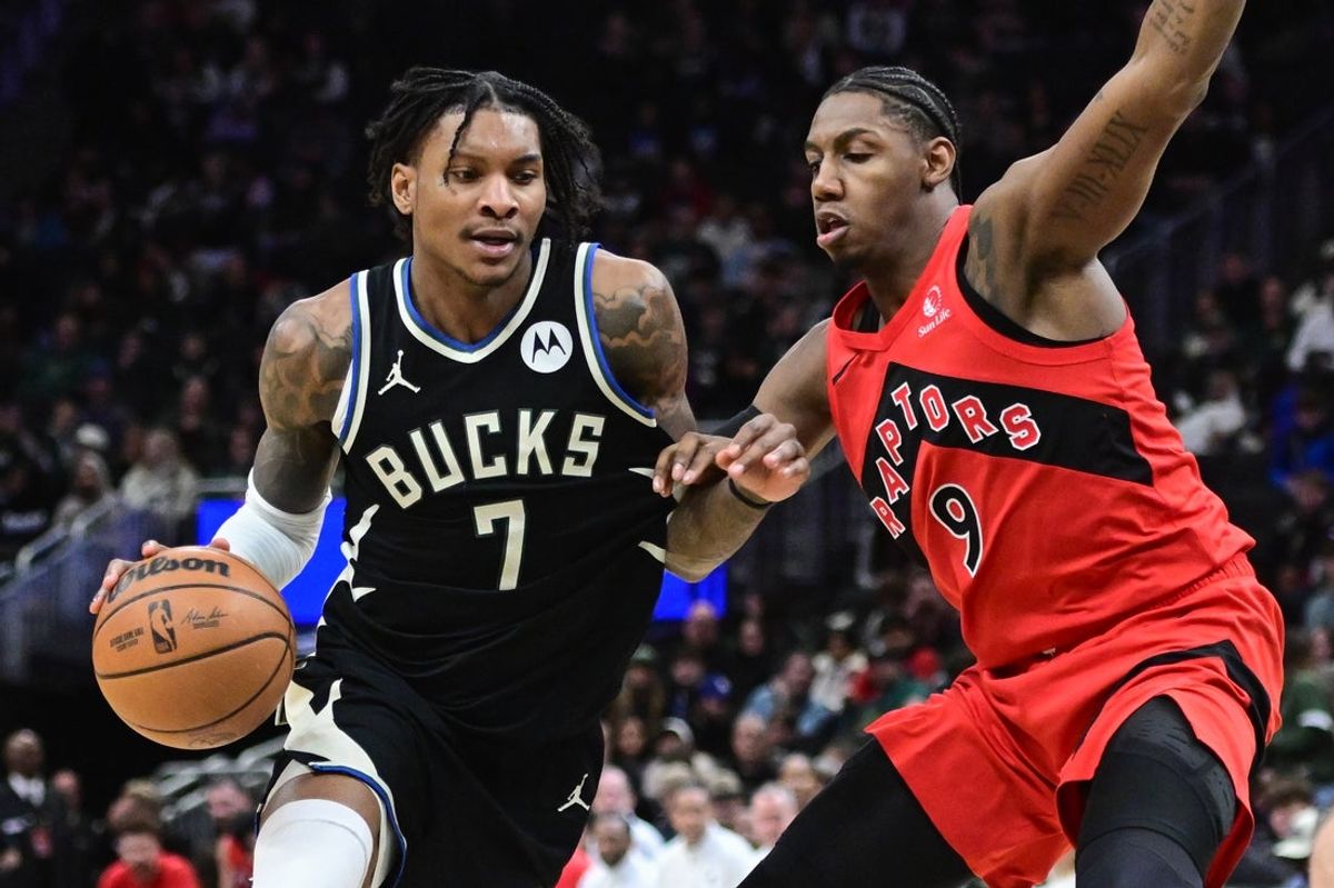 Feb 22, 2026; Milwaukee, Wisconsin, USA; Milwaukee Bucks guard Kevin Porter (7) drives for the basket against Toronto Raptors guard RJ Barrett (9) in the fourth quarter at Fiserv Forum. Mandatory Credit: Benny Sieu-Imagn Images