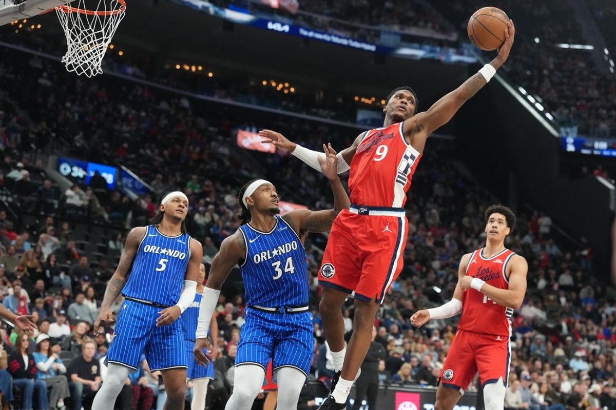 Feb 22, 2026; Inglewood, California, USA; LA Clippers guard Bennedict Mathurin (9) reaches for the ball against Orlando Magic forward Paolo Banchero (5) and center Wendell Carter Jr. (34) in the first half at Intuit Dome. Mandatory Credit: Kirby Lee-Imagn Images
