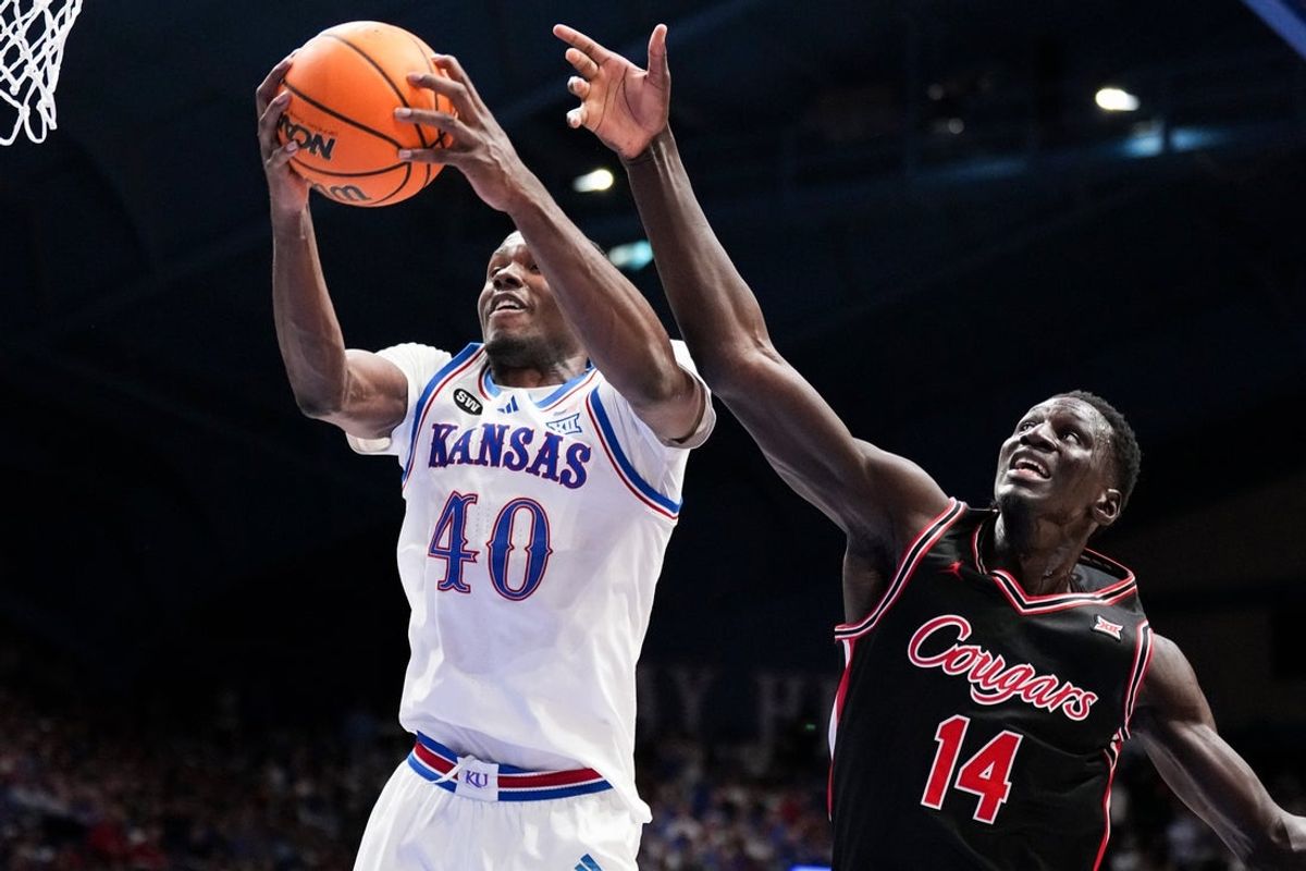 Feb 23, 2026; Lawrence, Kansas, USA; Kansas Jayhawks forward Flory Bidunga (40) rebounds as Houston Cougars forward Kalifa Sakho (14) defends during the first half of the game at Allen Fieldhouse. Mandatory Credit: Denny Medley-Imagn Images