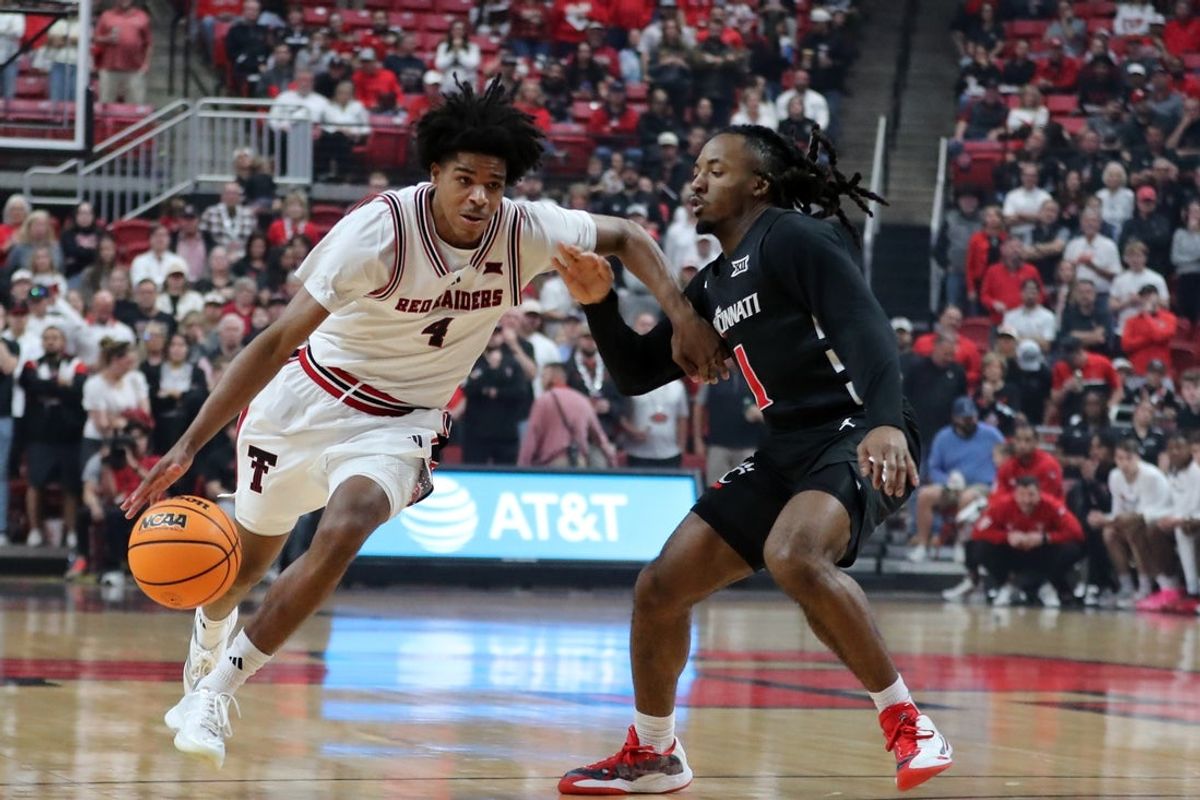Feb 24, 2026; Lubbock, Texas, USA; Texas Tech Red Raiders guard Christian Anderson (4) drives around Cincinnati Bearcats guard Day Day Thomas (1) in the first half at United Supermarkets Arena. Mandatory Credit: Michael C. Johnson-Imagn Images
