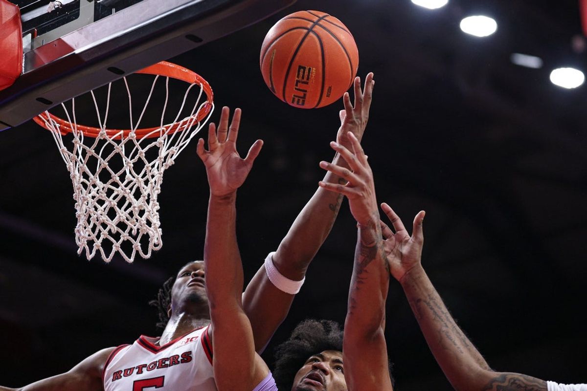 Feb 24, 2026; Piscataway, New Jersey, USA;  Rutgers Scarlet Knights guard Darren Buchanan Jr. (5) rebounds against Washington Huskies center Lathan Sommerville (24) during the second half at Jersey Mike's Arena. Mandatory Credit: Vincent Carchietta-Imagn Images
