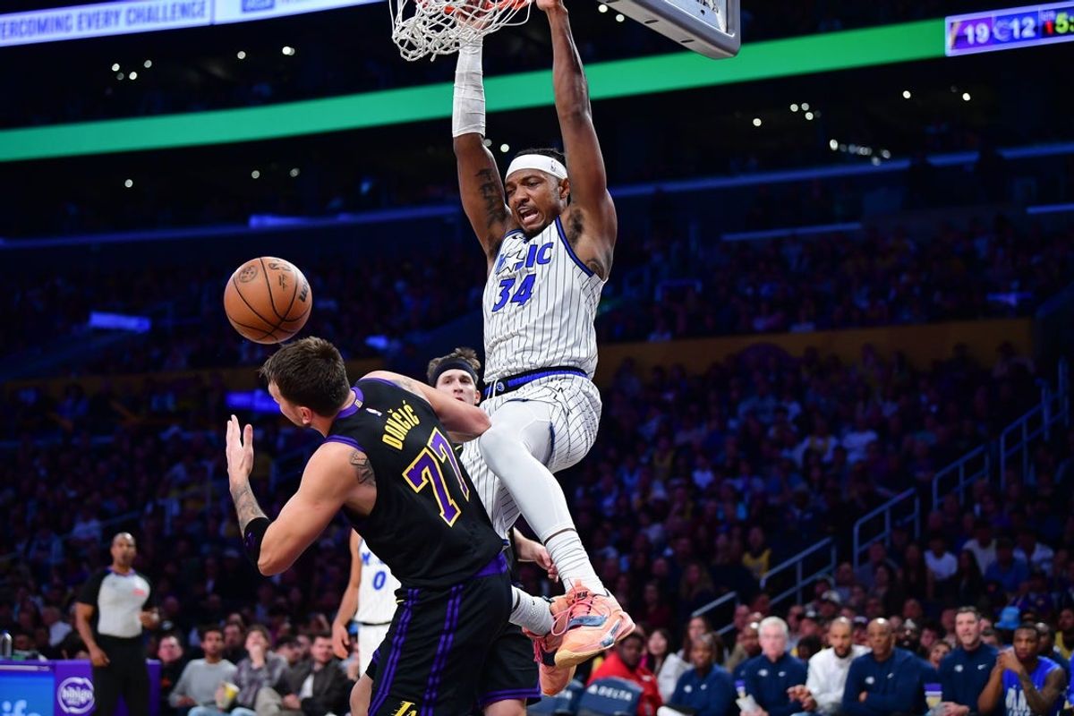Feb 24, 2026; Los Angeles, California, USA; Orlando Magic center Wendell Carter Jr. (34) dunks for the basket against Los Angeles Lakers guard Luka Doncic (77) during the first half at Crypto.com Arena. Mandatory Credit: Gary A. Vasquez-Imagn Images