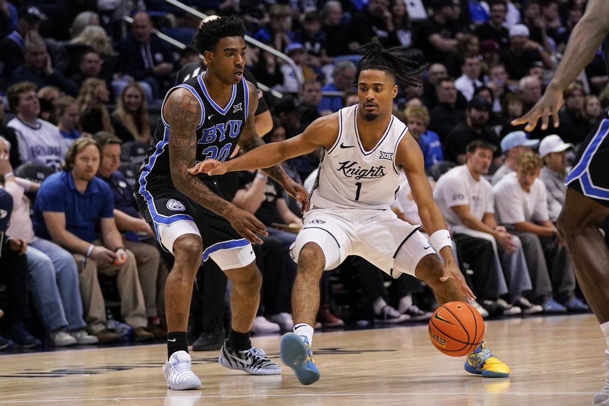 Feb 24, 2026; Provo, Utah, USA; UCF Knights guard Themus Fulks (1) dribbles the ball while being defended by BYU Cougars forward Kennard Davis Jr. (30) during the second half at Marriott Center. Mandatory Credit: Aaron Baker-Imagn Images