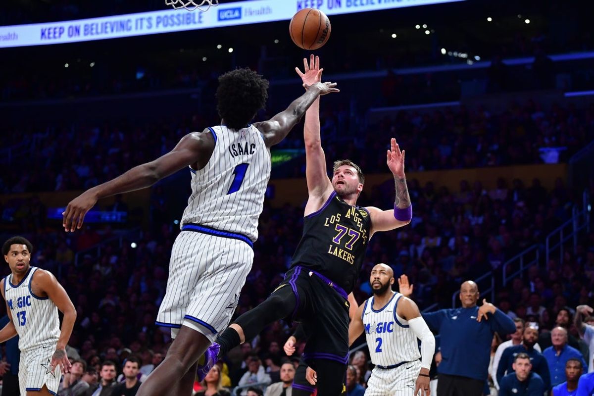 Feb 24, 2026; Los Angeles, California, USA; Los Angeles Lakers guard Luka Doncic (77) shoots against Orlando Magic forward Jonathan Isaac (1) during the second half at Crypto.com Arena. Mandatory Credit: Gary A. Vasquez-Imagn Images