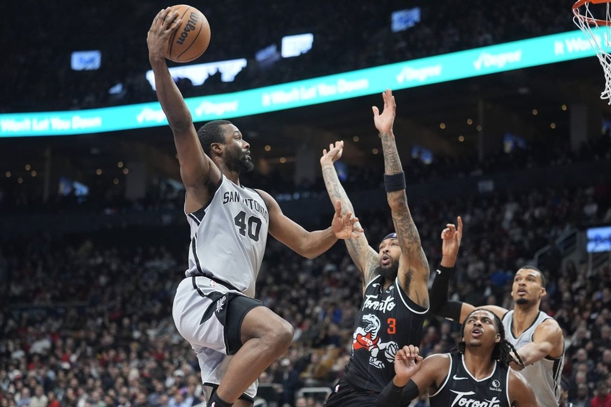 Feb 25, 2026; Toronto, Ontario, CAN; San Antonio Spurs forward Harrison Barnes (40) goes up to make a basket against Toronto Raptors forward Brandon Ingram (3) and  forward Collin Murray-Boyles (12) during the first half at Scotiabank Arena. Mandatory Credit: John E. Sokolowski-Imagn Images