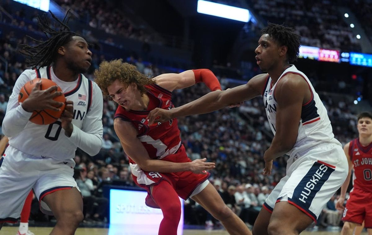 Feb 25, 2026; Hartford, Connecticut, USA; UConn Huskies forward Tarris Reed Jr. (5) and guard Malachi Smith (0) work for the ball against St. John's Red Storm forward Rubén Prey (17) in the second half at PeoplesBank Arena. Mandatory Credit: David Butler II-Imagn Images