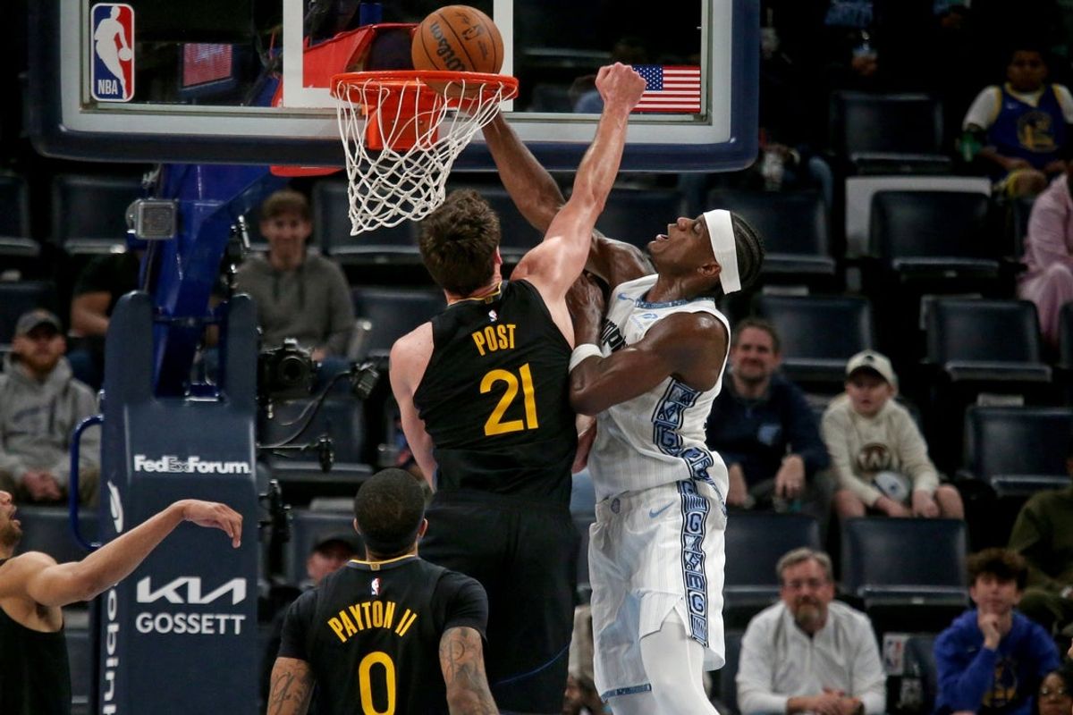 Feb 25, 2026; Memphis, Tennessee, USA; Memphis Grizzlies forward Taylor Hendricks (22) dunks as Golden State Warriors center Quinten Post (21) defends during the fourth quarter at FedExForum. Mandatory Credit: Petre Thomas-Imagn Images