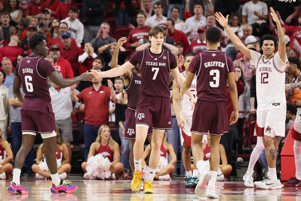 Feb 25, 2026; Fayetteville, Arkansas, USA; Arkansas Razorbacks forward Malique Ewin (12) reacts after being called for a foul against Texas A&M Aggies forward Zach Clemency (7) during the second half at Bud Walton Arena. Arkansas won 99-84. Mandatory Credit: Nelson Chenault-Imagn Images