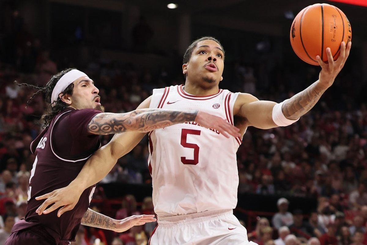 Feb 25, 2026; Fayetteville, Arkansas, USA; Arkansas Razorbacks guard Darius Acuff Jr. (5) drives to the basket as Texas A&M Aggies guard Pop Isaacs (2) defends during the second half at Bud Walton Arena. Arkansas won 99-84. Mandatory Credit: Nelson Chenault-Imagn Images