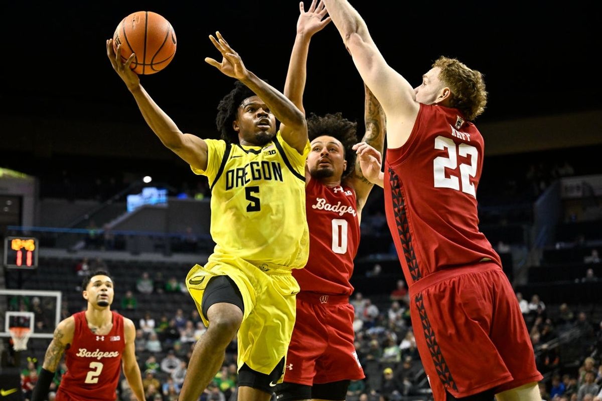 Feb 25, 2026; Eugene, Oregon, USA; Oregon Ducks guard Takai Simpkins (5) drives to the basket and is fouled by Wisconsin Badgers guard Braeden Carrington (0) during the first half at Matthew Knight Arena. Mandatory Credit: Craig Strobeck-Imagn Images
