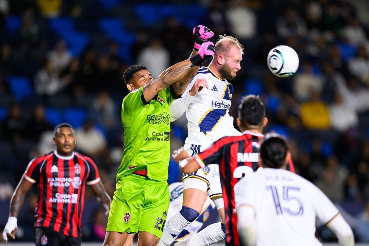 Feb 25, 2026; Carson, California, USA; Sporting San Miguelito goalkeeper Jose Calderon (26), center left, and LA Galaxy forward João Klauss (99), center right, vie for the ball during the second half of a Concacaf Champions Cup soccer game at Dignity Health Sports Park. Mandatory Credit: William Liang-Imagn Images