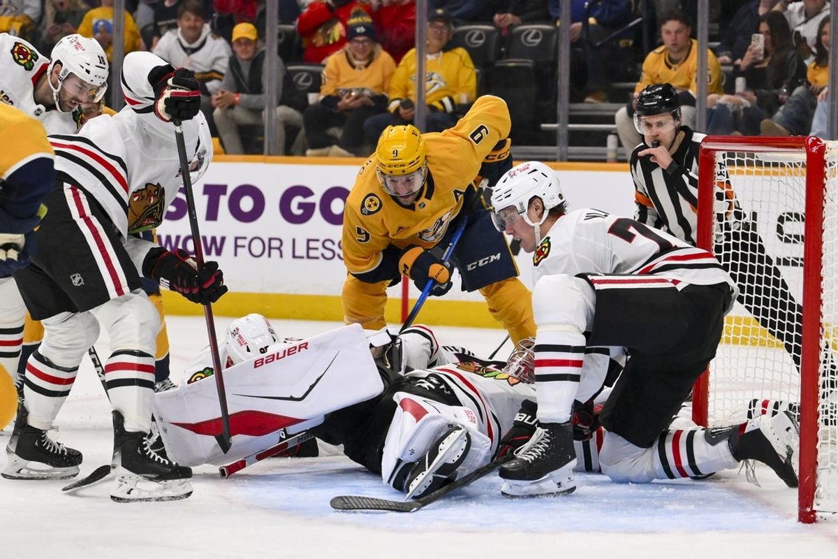 Feb 26, 2026; Nashville, Tennessee, USA; Chicago Blackhawks goaltender Spencer Knight (30) blocks the shot of Nashville Predators left wing Filip Forsberg (9) during the first period at Bridgestone Arena. Mandatory Credit: Steve Roberts-Imagn Images