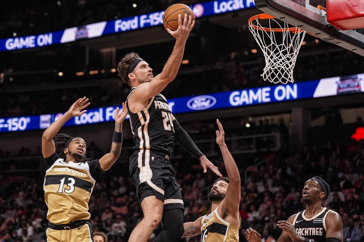 Feb 26, 2026; Atlanta, Georgia, USA; Atlanta Hawks forward Corey Kispert (24) goes to the basket between Washington Wizards guard Sharife Cooper (13) and forward Anthony Gill (16) during the second half at State Farm Arena. Mandatory Credit: Dale Zanine-Imagn Images