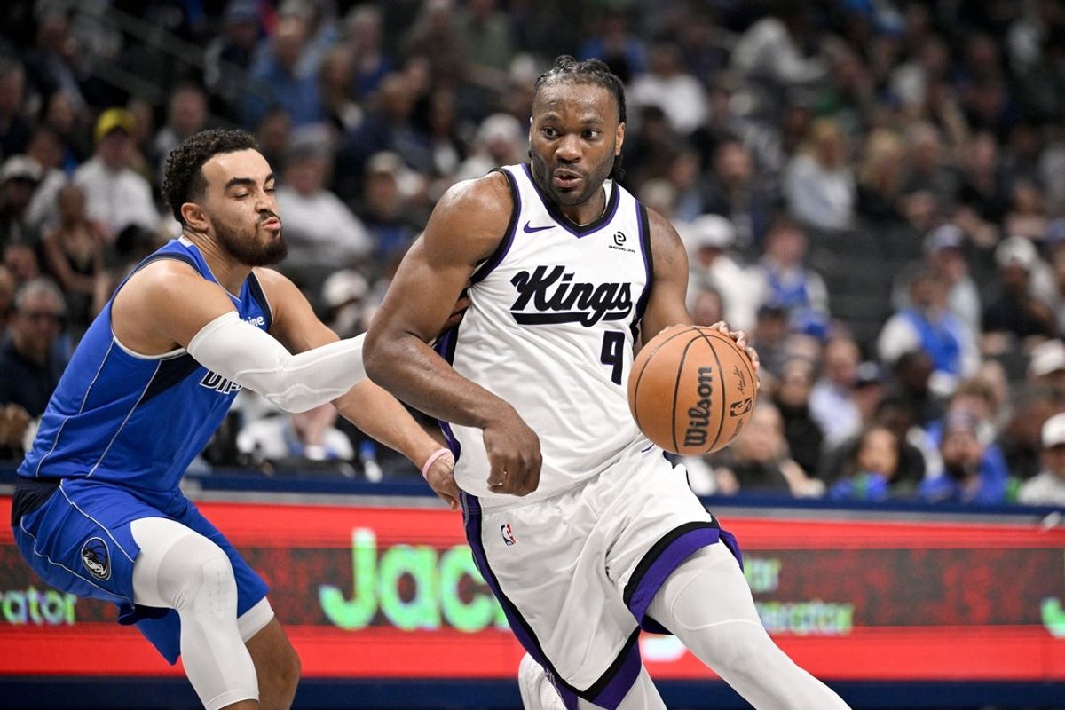 Feb 26, 2026; Dallas, Texas, USA; Sacramento Kings forward Precious Achiuwa (9) drives to the basket past Dallas Mavericks guard Tyus Jones (1) during the second half at the American Airlines Center. Mandatory Credit: Jerome Miron-Imagn Images