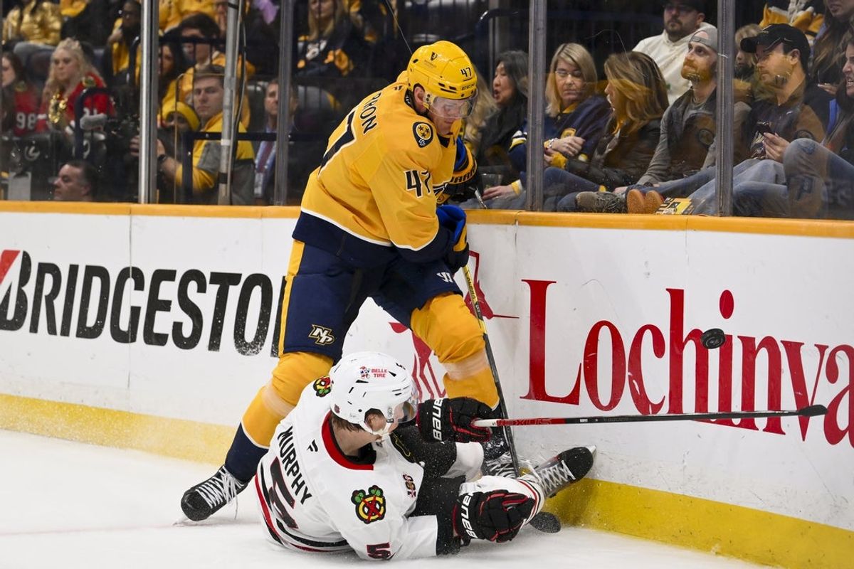 Feb 26, 2026; Nashville, Tennessee, USA;  Nashville Predators right wing Michael McCarron (47) and Chicago Blackhawks defenseman Connor Murphy (5) battle for the puck during the third period at Bridgestone Arena. Mandatory Credit: Steve Roberts-Imagn Images