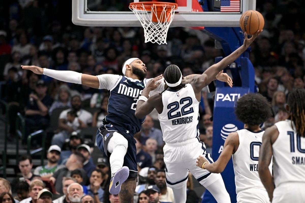 Feb 27, 2026; Dallas, Texas, USA; Memphis Grizzlies forward Taylor Hendricks (22) drives to the basket past Dallas Mavericks forward Daniel Gafford (21) during the second quarter at the American Airlines Center. Mandatory Credit: Jerome Miron-Imagn Images