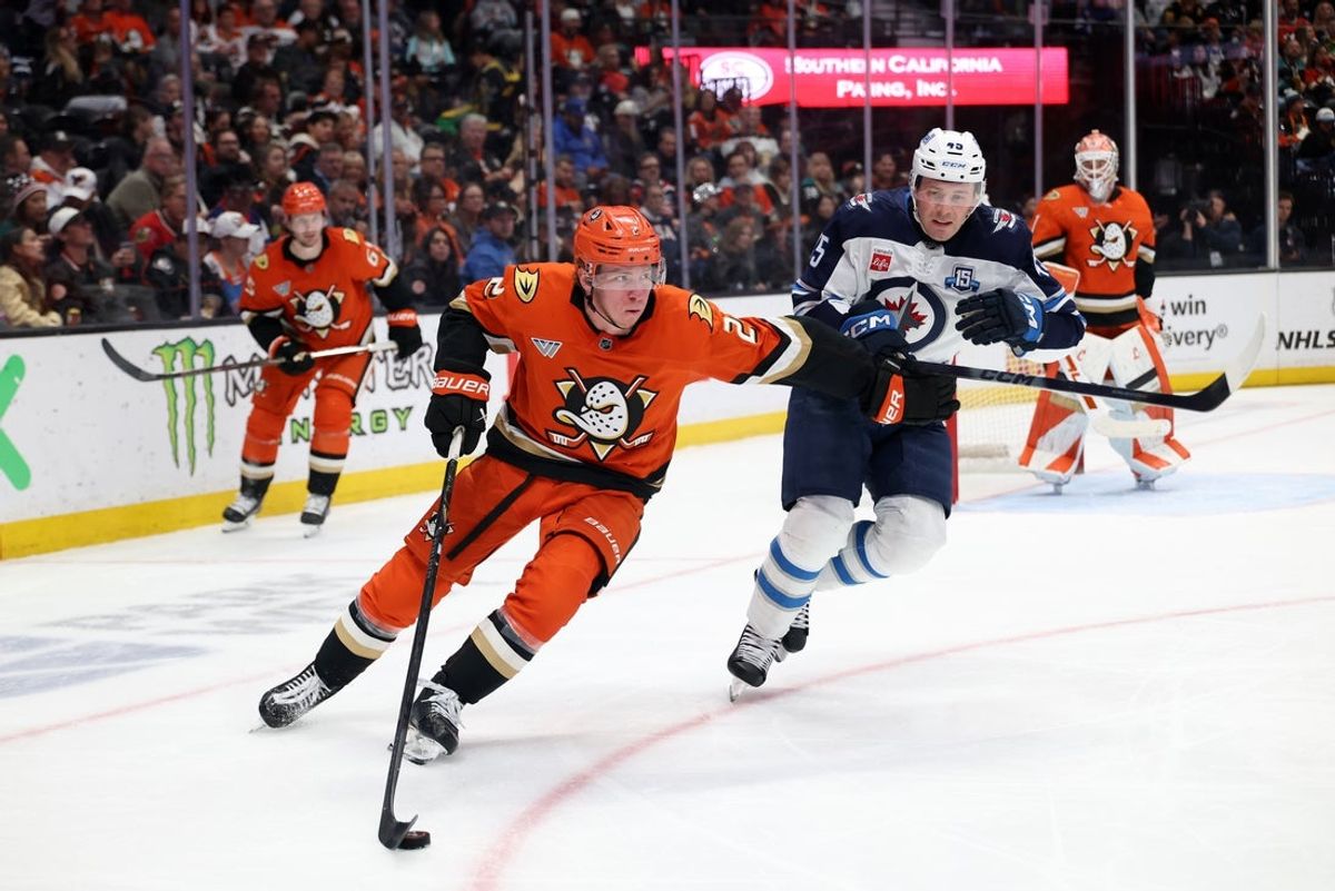 Feb 27, 2026; Anaheim, California, USA;  Anaheim Ducks defenseman Jackson LaCombe (2) fights for the puck against Winnipeg Jets left wing Cole Koepke (45) during the second period at Honda Center. Mandatory Credit: Kiyoshi Mio-Imagn Images