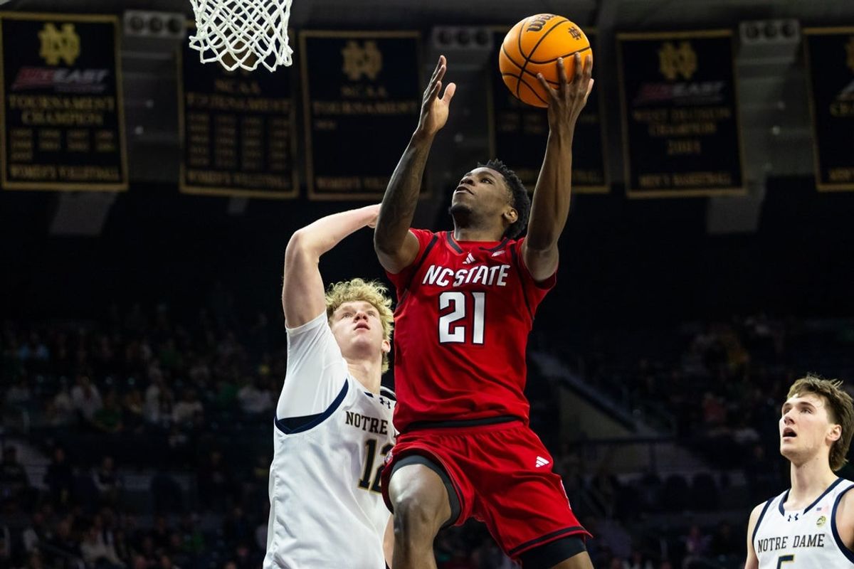 Feb 28, 2026; South Bend, Indiana, USA; NC State Wolfpack guard Terrance Arceneaux (21) drives as Notre Dame Fighting Irish forward Garrett Sundra (12) defends during the second half at Purcell Pavilion at the Joyce Center. Mandatory Credit: Michael Caterina-Imagn Images