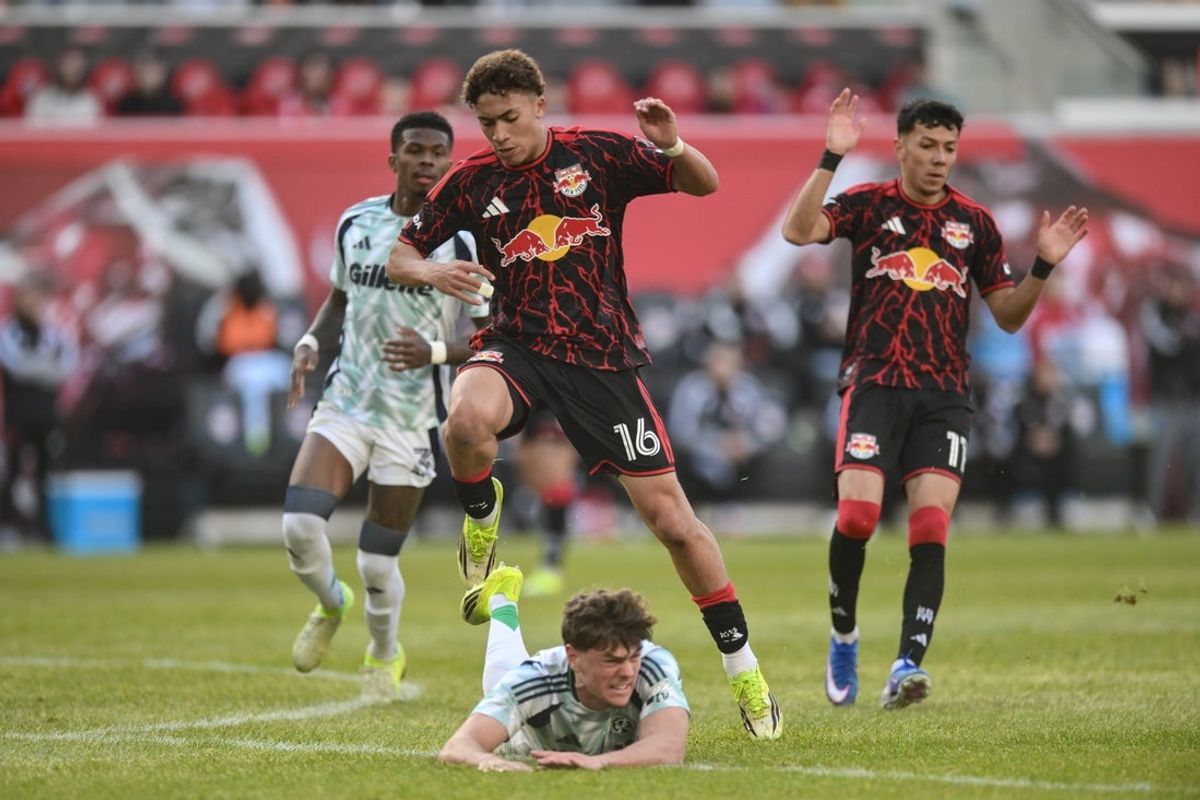 Feb 28, 2026; Harrison, New Jersey, USA; Red Bull New York forward Julian Hall (16) leaps to avoid New England Revolution defender Ilay Feingold (12) during the second half at Sports Illustrated Stadium. Mandatory Credit: John Jones-Imagn Images