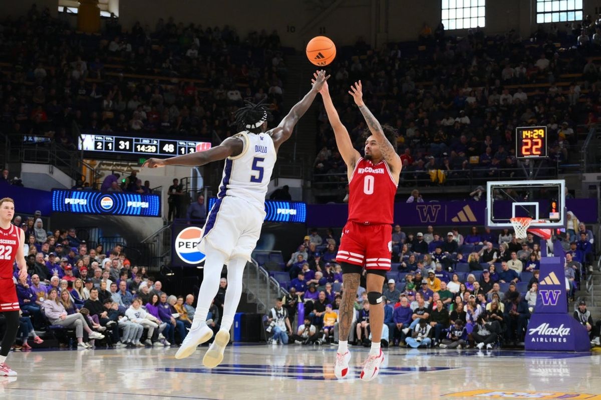 Feb 28, 2026; Seattle, Washington, USA; Wisconsin Badgers guard Braeden Carrington (0) shoots a three point shot over Washington Huskies guard Zoom Diallo (5) during the second half at Alaska Airlines Arena at Hec Edmundson Pavilion. Mandatory Credit: Steven Bisig-Imagn Images