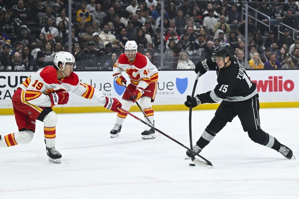 Feb 28, 2026; Los Angeles, California, USA; Los Angeles Kings center Alex Turcotte (15) shoots the puck during the second period against the Calgary Flames at Crypto.com Arena. Mandatory Credit: Griffin Hooper-Imagn Images