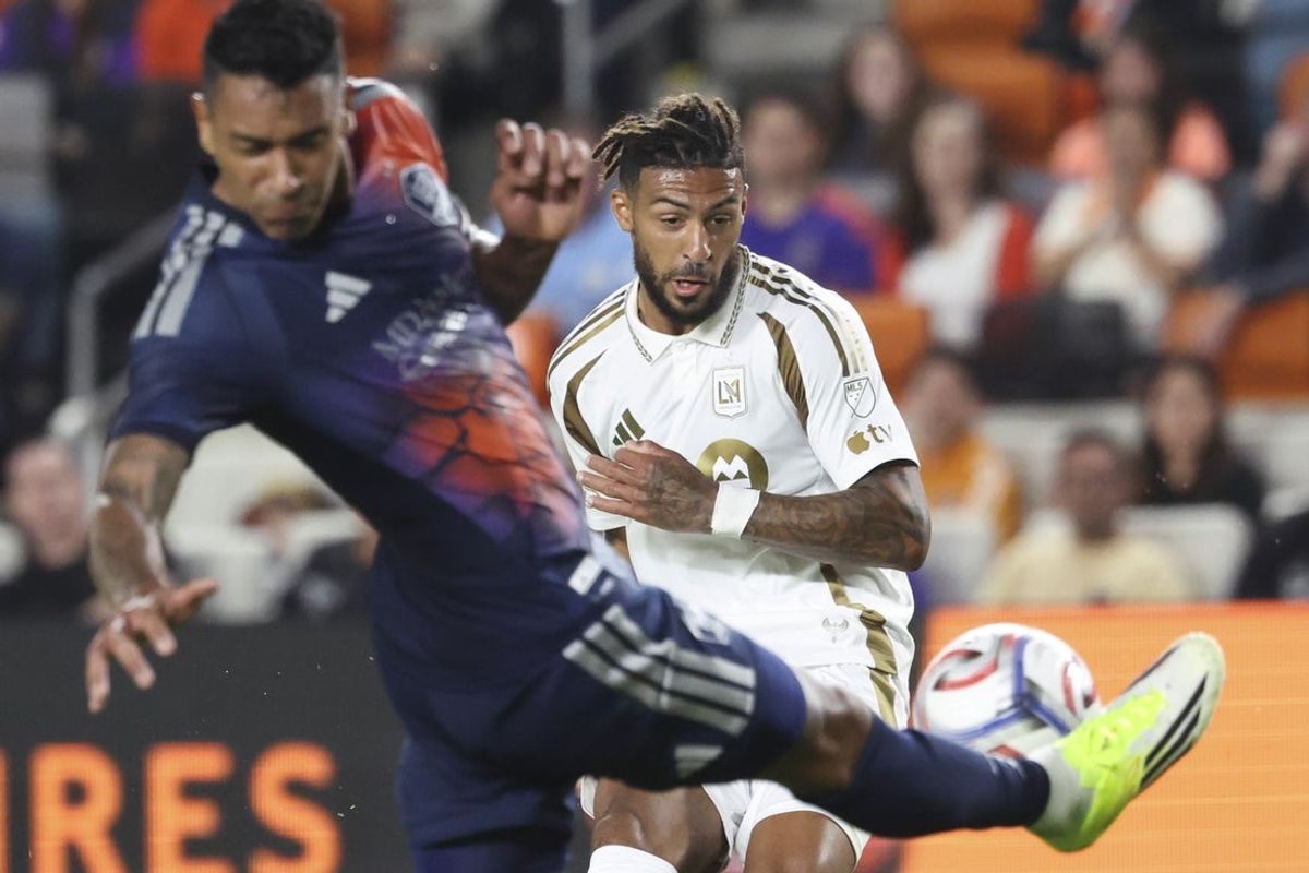 Feb 28, 2026; Houston, Texas, USA; Los Angeles FC forward Denis Bouanga (99) shoots the ball as Houston Dynamo FC defender Antonio Carlos (3) defends during the first half at Shell Energy Stadium. Mandatory Credit: Troy Taormina-Imagn Images