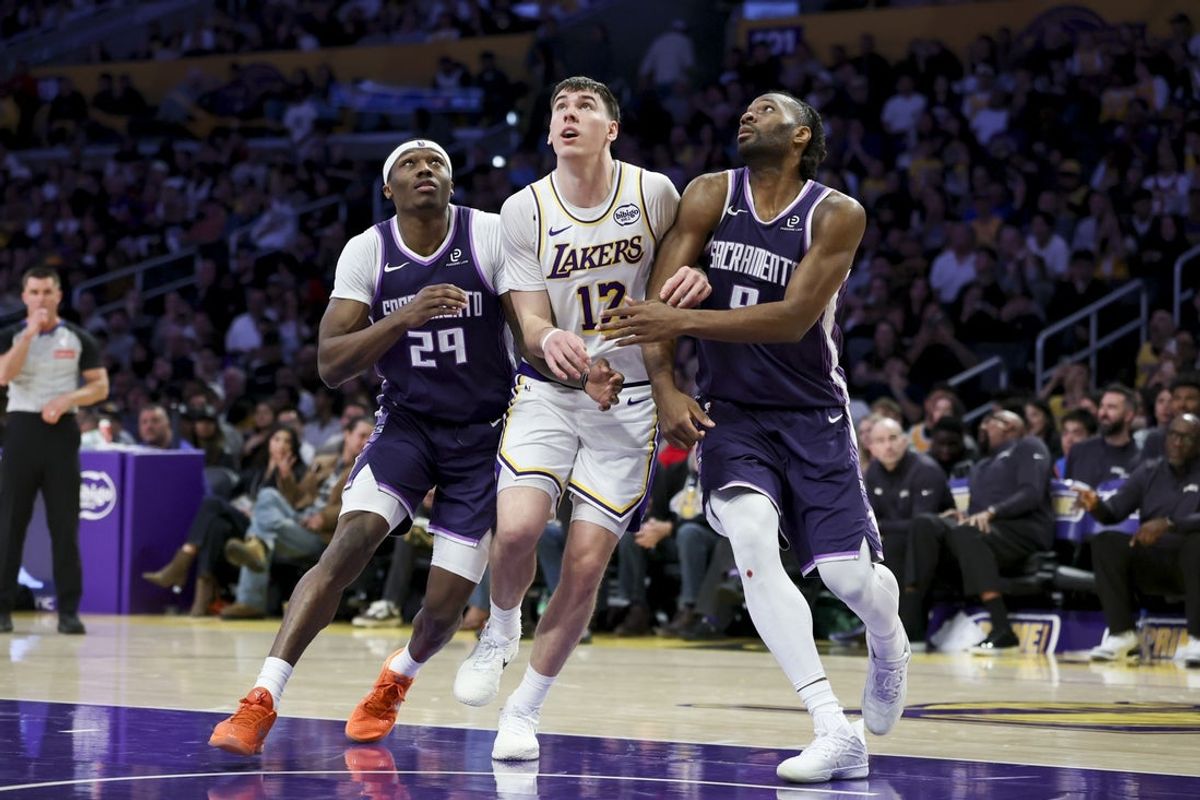 Mar 1, 2026; Los Angeles, California, USA; Los Angeles Lakers forward Jake LaRavia (12) fights for the ball between Sacramento Kings guard Daeqwon Plowden (29) and forward Precious Achiuwa (9) during the fourth quarter at Crypto.com Arena. Mandatory Credit: William Navarro-Imagn Images