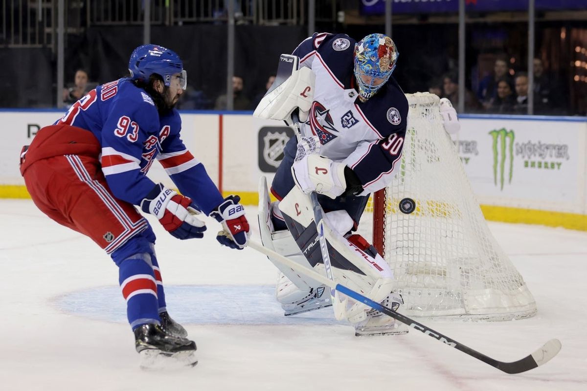 Mar 2, 2026; New York, New York, USA; Columbus Blue Jackets goaltender Elvis Merzlikins (90) plays the puck against New York Rangers center Mika Zibanejad (93) during the second period at Madison Square Garden. Mandatory Credit: Brad Penner-Imagn Images