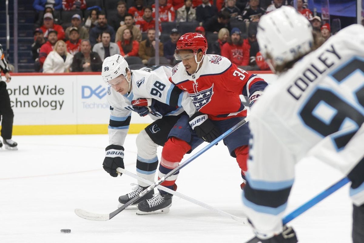Mar 3, 2026; Washington, District of Columbia, USA; Utah Mammoth defenseman Mikhail Sergachev (98) battles for the puck with Washington Capitals right wing Justin Sourdif (34) during the first period at Capital One Arena. Mandatory Credit: Amber Searls-Imagn Images