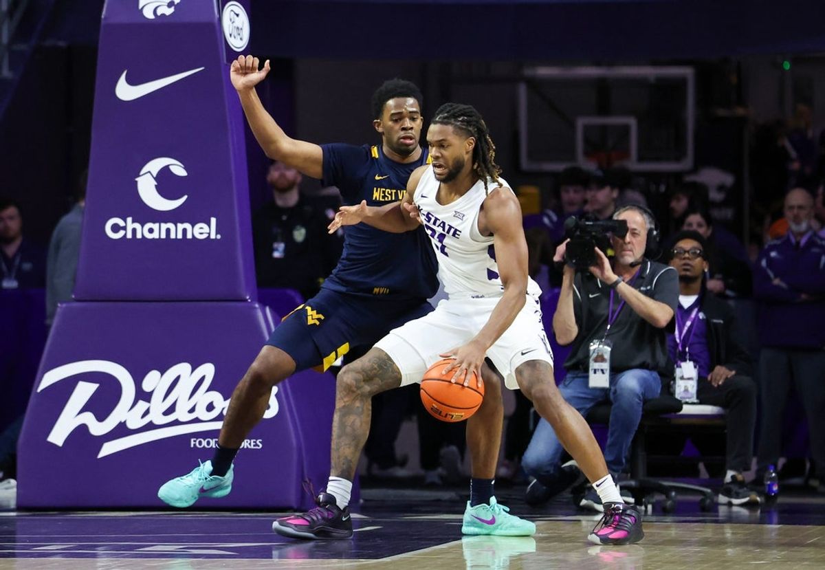 Mar 3, 2026; Manhattan, Kansas, USA; Kansas State Wildcats forward Khamari McGriff (21) is guarded by West Virginia Mountaineers forward DJ Thomas (5) during the first half at Bramlage Coliseum. Mandatory Credit: Scott Sewell-Imagn Images