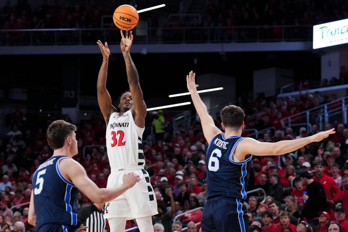 Mar 3, 2026; Cincinnati, Ohio, USA;  Cincinnati Bearcats forward Jalen Celestine (32) attempts a 3-point shot against BYU Cougars forward Mihailo Boskovic (5) and guard Aleksej Kostic (6) in the first half at Fifth Third Arena. Mandatory Credit: Aaron Doster-Imagn Images