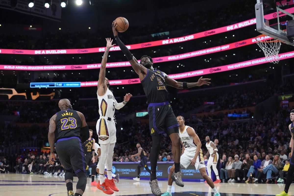Mar 3, 2026; Los Angeles, California, USA; Los Angeles Lakers center Deandre Ayton (5) and forward LeBron James (23) and New Orleans Pelicans guard Dejounte Murray (5) reach for the ball in the first half at Crypto.com Arena. Mandatory Credit: Kirby Lee-Imagn Images