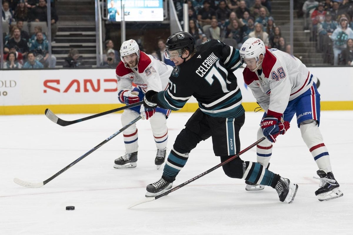 Mar 3, 2026; San Jose, California, USA;  San Jose Sharks center Macklin Celebrini (71) shoots the puck during the second period against Montreal Canadiens defenseman Noah Dobson (53) and Montreal Canadiens defenseman Lane Hutson (48) at SAP Center at San Jose. Mandatory Credit: Stan Szeto-Imagn Images