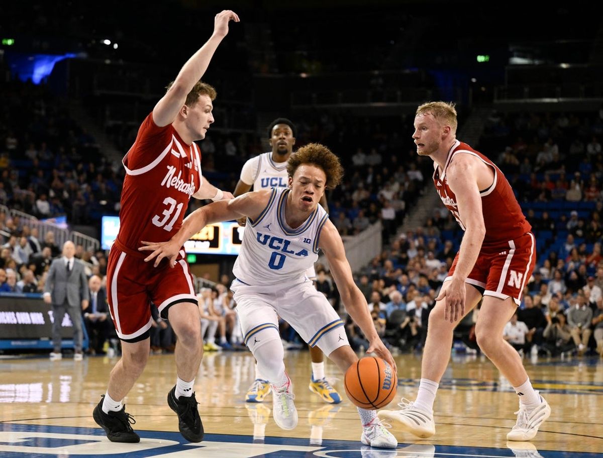 Mar 3, 2026; Los Angeles, California, USA; UCLA Bruins guard Trent Perry (0) drives to the basket between Nebraska Cornhuskers guard Cale Jacobsen (31) and Nebraska Cornhuskers forward Rienk Mast (51) during the first half at Pauley Pavilion presented by Wescom Financial. Mandatory Credit: Robert Hanashiro-Imagn Images