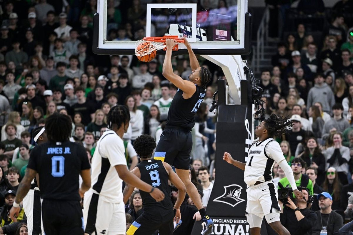 Mar 4, 2026; Providence, Rhode Island, USA; Marquette Golden Eagles forward Royce Parham (13) hangs from the rim after dunking the ball against the Providence Friars during the first half at Amica Mutual Pavilion. Mandatory Credit: Eric Canha-Imagn Images