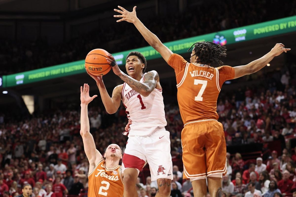 Mar 4, 2026; Fayetteville, Arkansas, USA; Arkansas Razorbacks guard Meleek Thomas (1) shoots as Texas Longhorns guards Chendall Weaver (2) and Simeon Wilcher (7) defend  in the first half at Bud Walton Arena. Mandatory Credit: Nelson Chenault-Imagn Images