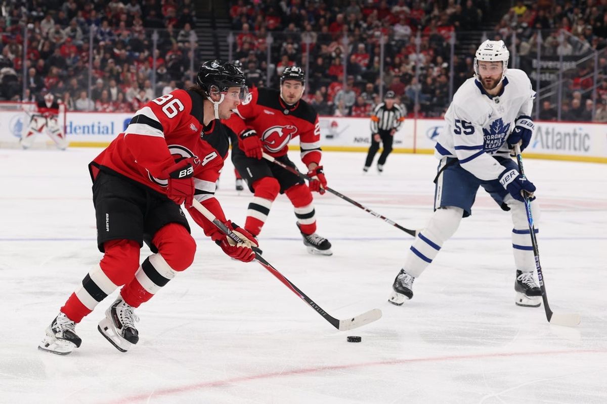 Mar 4, 2026; Newark, New Jersey, USA; New Jersey Devils center Jack Hughes (86) skates with the puck as Toronto Maple Leafs center Nicolas Roy (55) defends during the second period at Prudential Center. Mandatory Credit: Ed Mulholland-Imagn Images