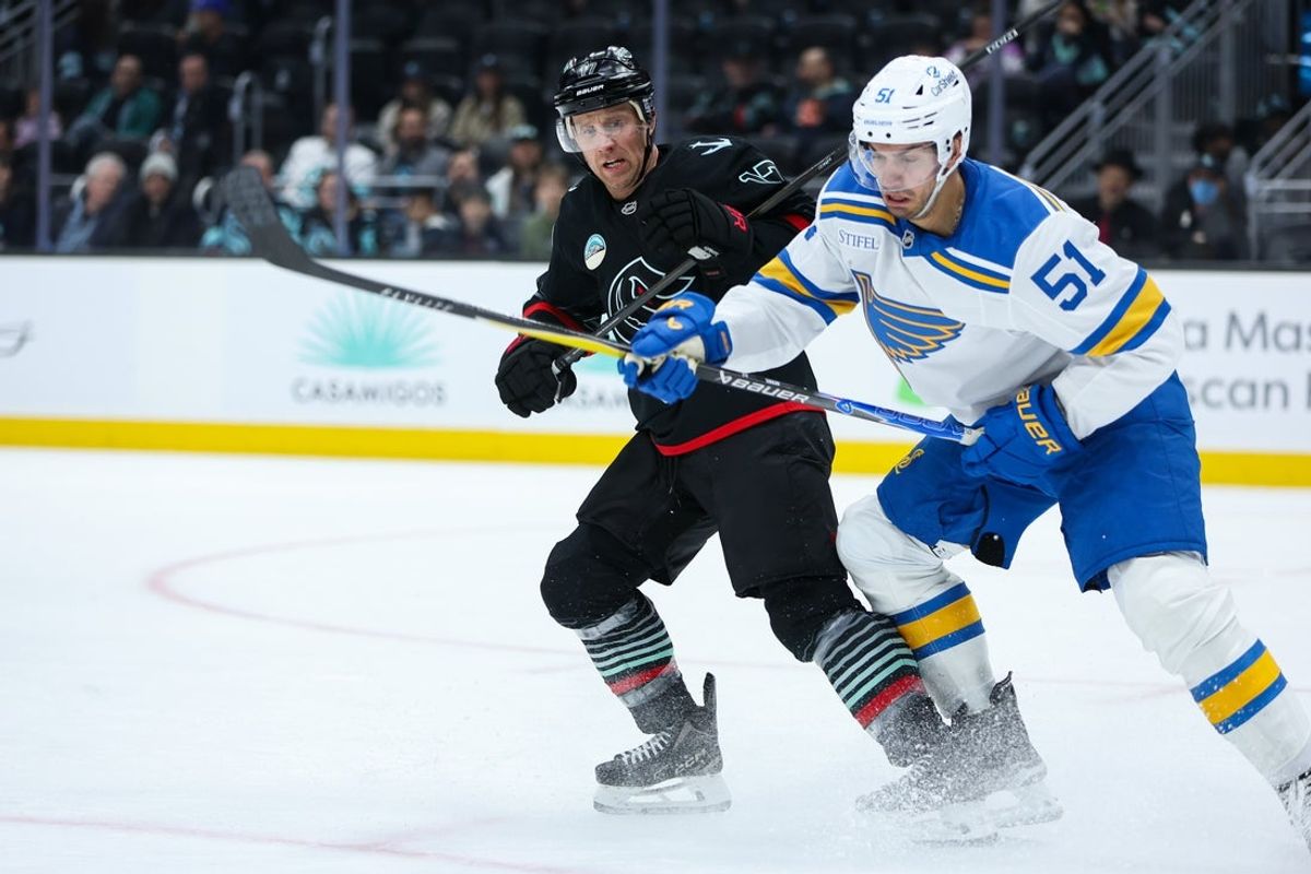 Mar 4, 2026; Seattle, Washington, USA;  Seattle Kraken left wing Jaden Schwartz (17) and St. Louis Blues defenseman Matthew Kessel (51) battle for the puck in the second period at Climate Pledge Arena. Mandatory Credit: Kevin Ng-Imagn Images