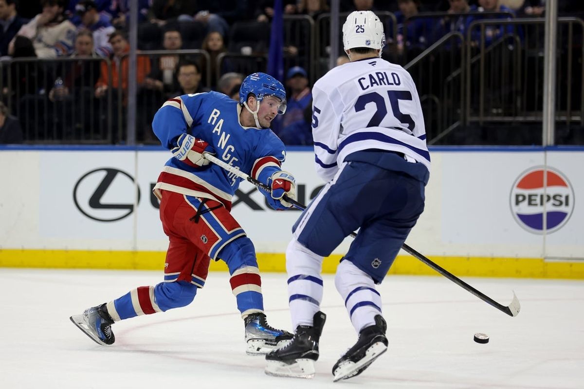 Mar 5, 2026; New York, New York, USA; New York Rangers left wing Alexis Lafreniere (13) takes a shot against Toronto Maple Leafs defenseman Brandon Carlo (25) during the second period at Madison Square Garden. Mandatory Credit: Brad Penner-Imagn Images
