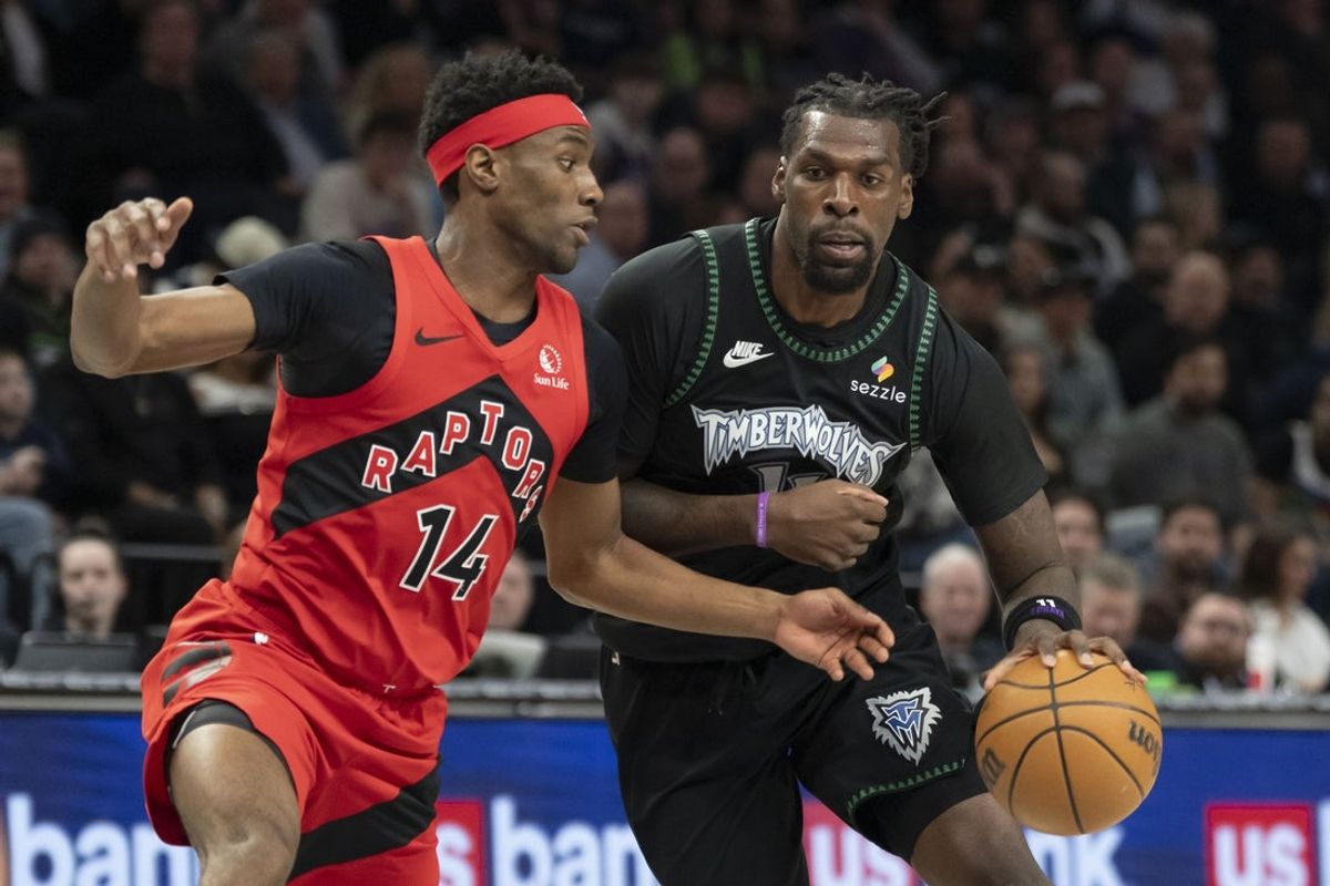 Mar 5, 2026; Minneapolis, Minnesota, USA; Minnesota Timberwolves center Naz Reid (11) dribbles the ball past Toronto Raptors guard Ja'kobe Walter (14) in the first half at Target Center. Mandatory Credit: Jesse Johnson-Imagn Images
