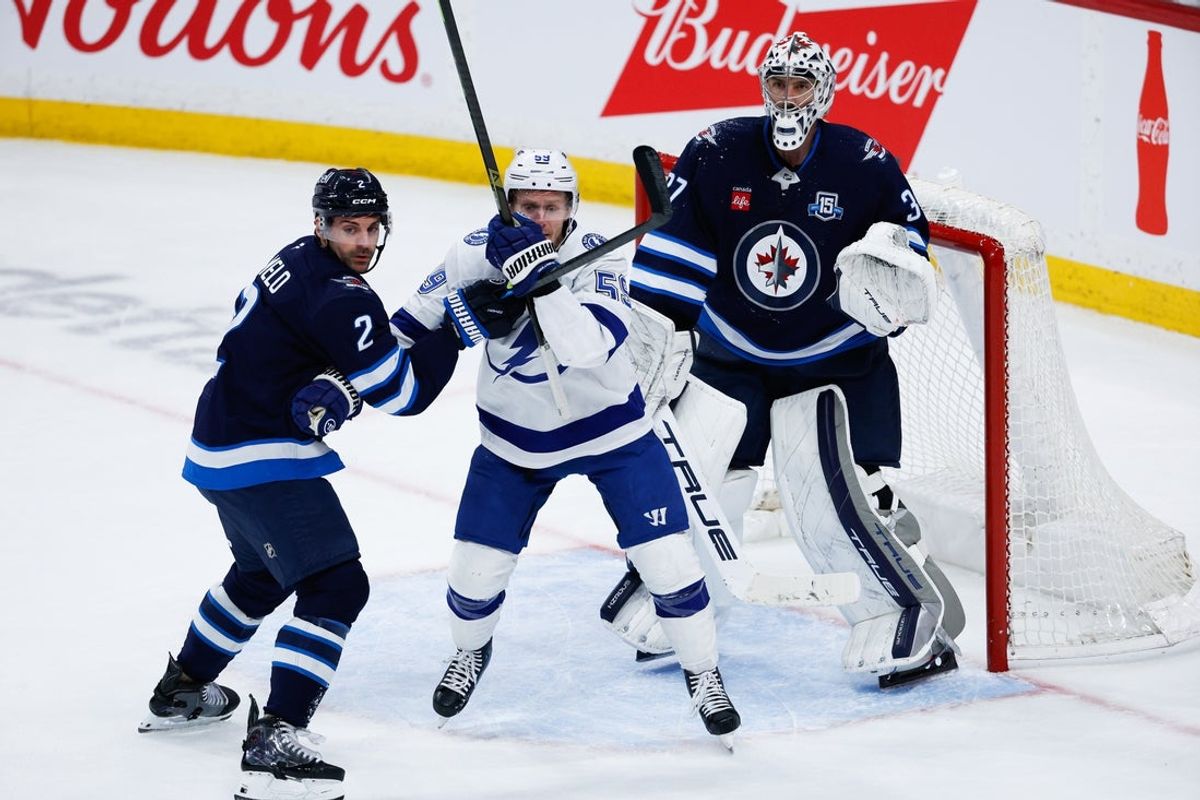 Mar 5, 2026; Winnipeg, Manitoba, CAN;  Winnipeg Jets defenseman Dylan DeMelo (2) jostles for position with Tampa Bay Lightning forward Jake Guentzel (59) in front of Winnipeg Jets goalie Connor Hellebuyck (37) during the first period at Canada Life Centre. Mandatory Credit: Terrence Lee-Imagn Images